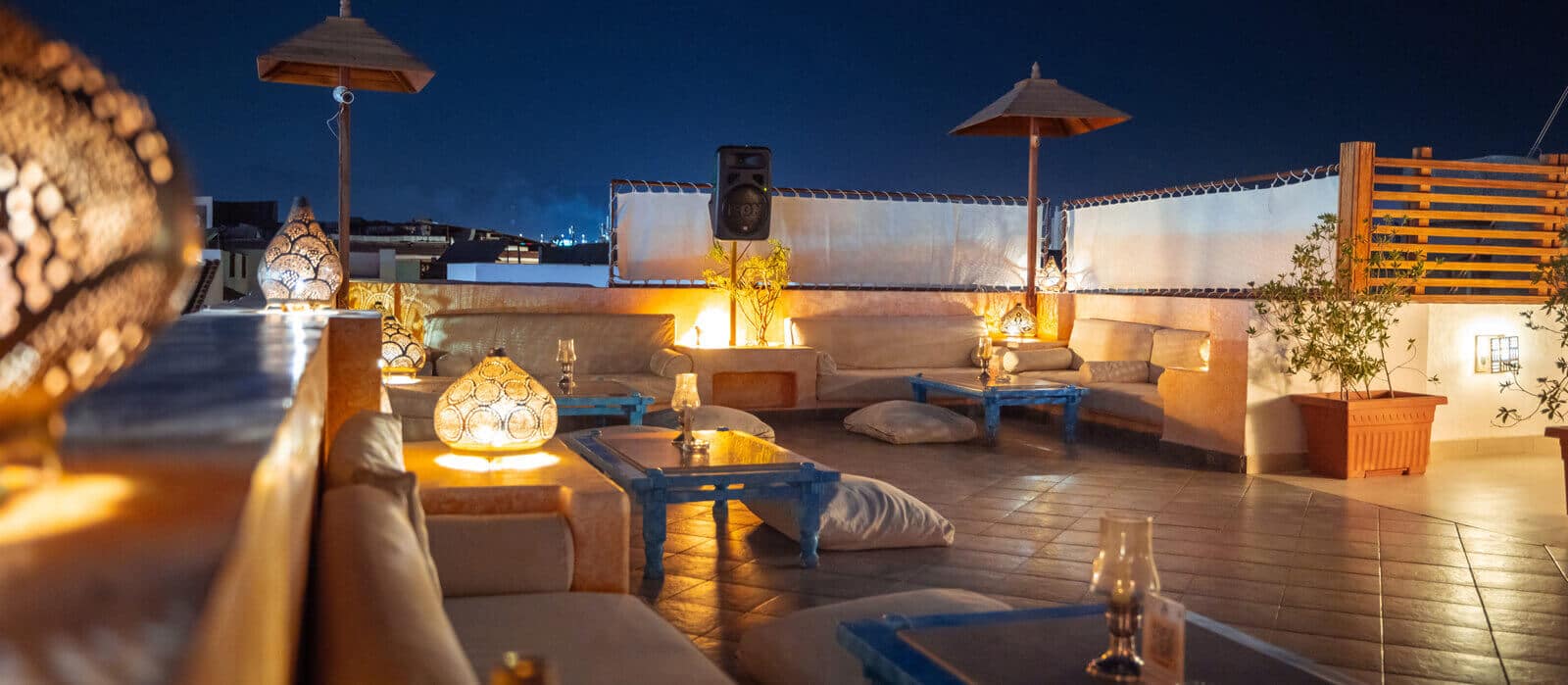 Camel Rooftop Bar relaxing low seating area at night.