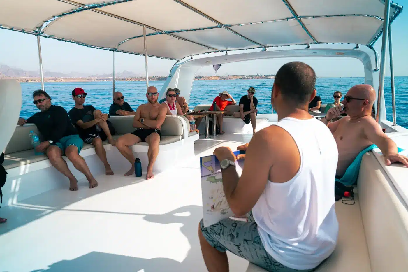 Divers relaxing on the shaded deck during a dive briefing
